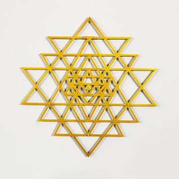 Gold geometric star design on a light gray background