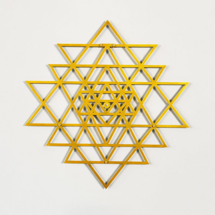 Gold geometric star design on a light gray background