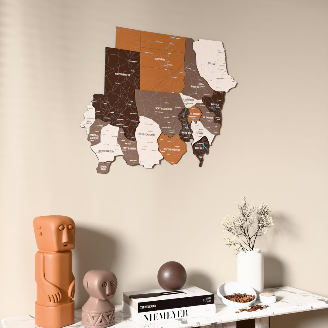 Soil Sudan wooden wall map on a beige wall above a console with figurines