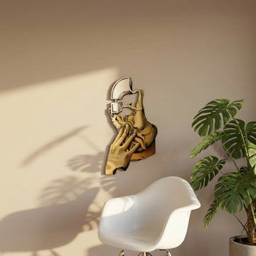 Surrealist silhouette metal wall art on a sunlit wall above a white chair and monstera