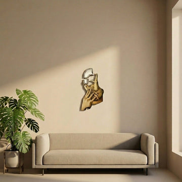 Surrealist silhouette metal wall art in a room with a beige sofa and monstera