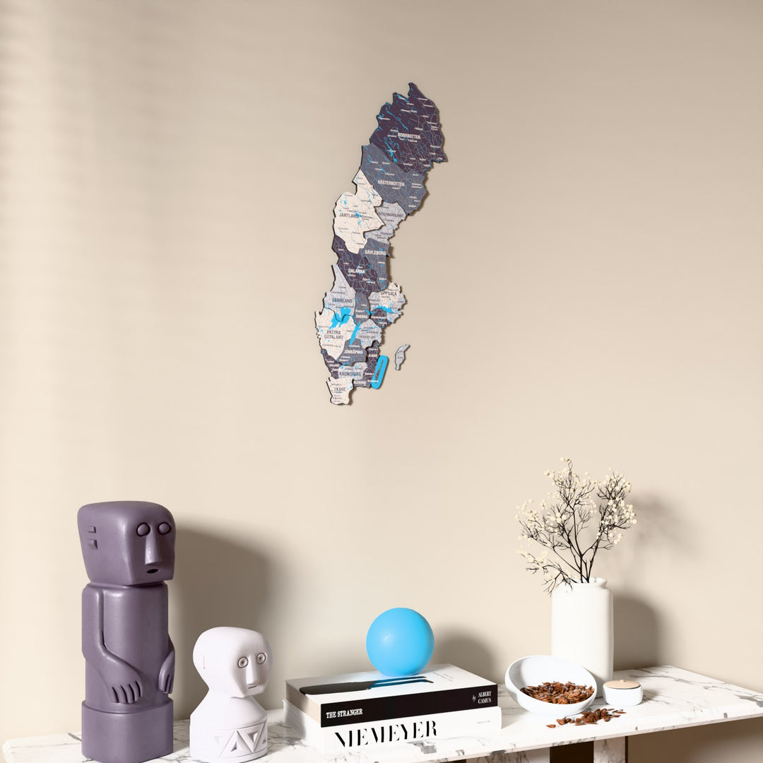 Nimbus Sweden wooden wall map on a beige wall above a console with figurines