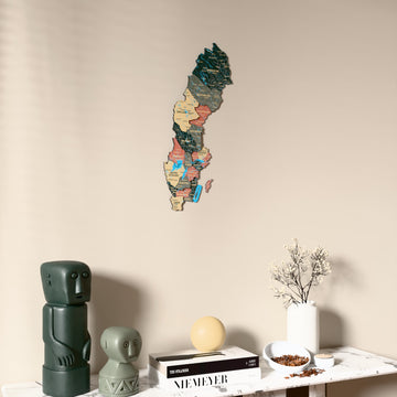 Sage Sweden wooden wall map on a beige wall above a console with figurines