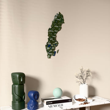 Satellite Sweden wooden wall map on a beige wall above a console with figurines