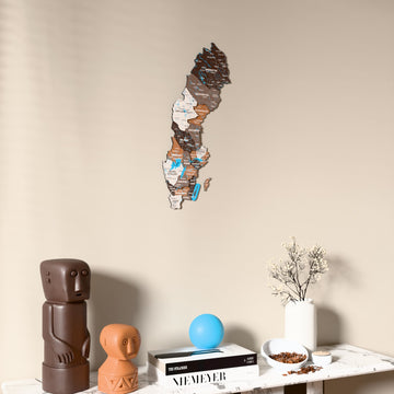 Soil Sweden wooden wall map on a beige wall above a console with figurines