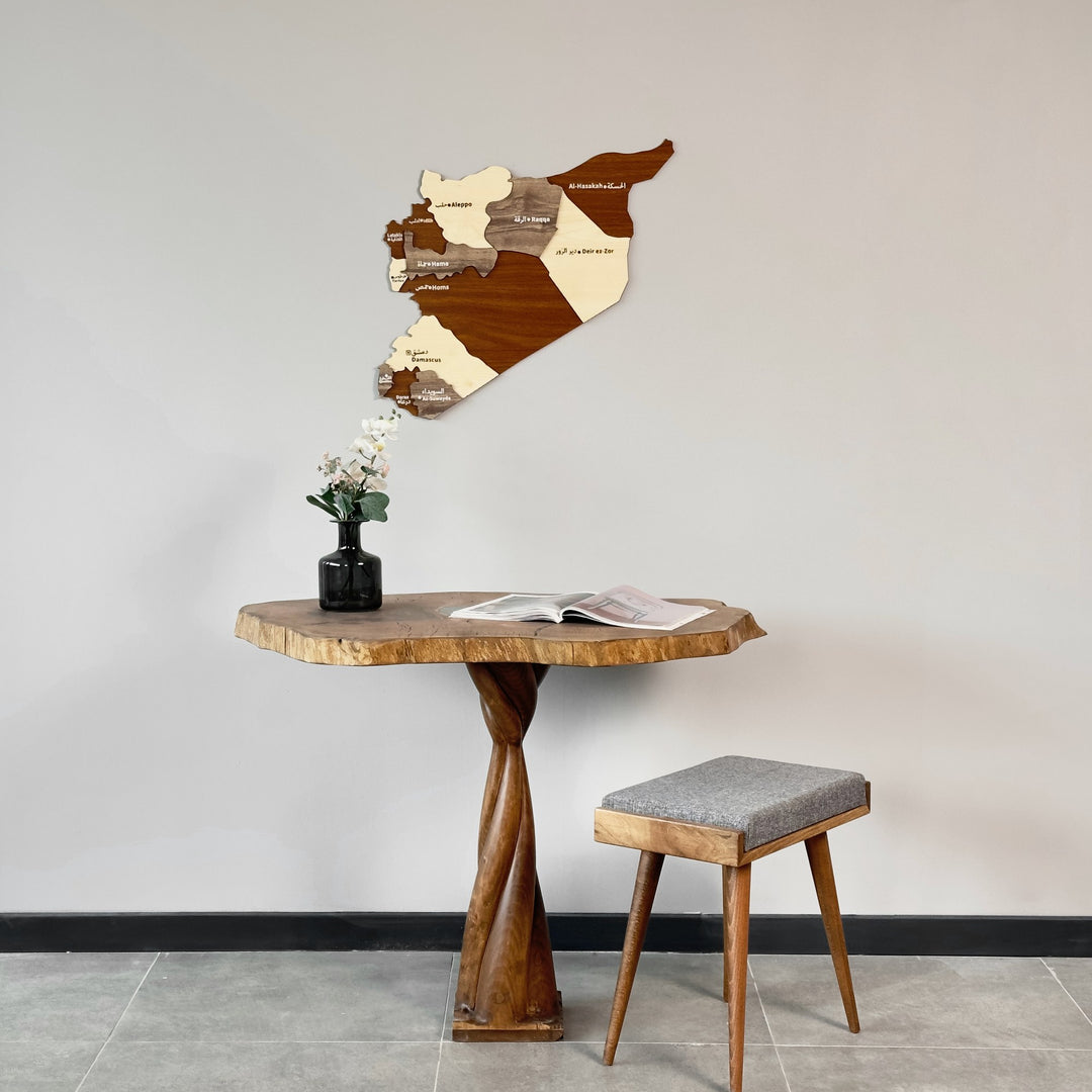 Syria wooden wall map above a live-edge table with a twisted base and a vase of flowers