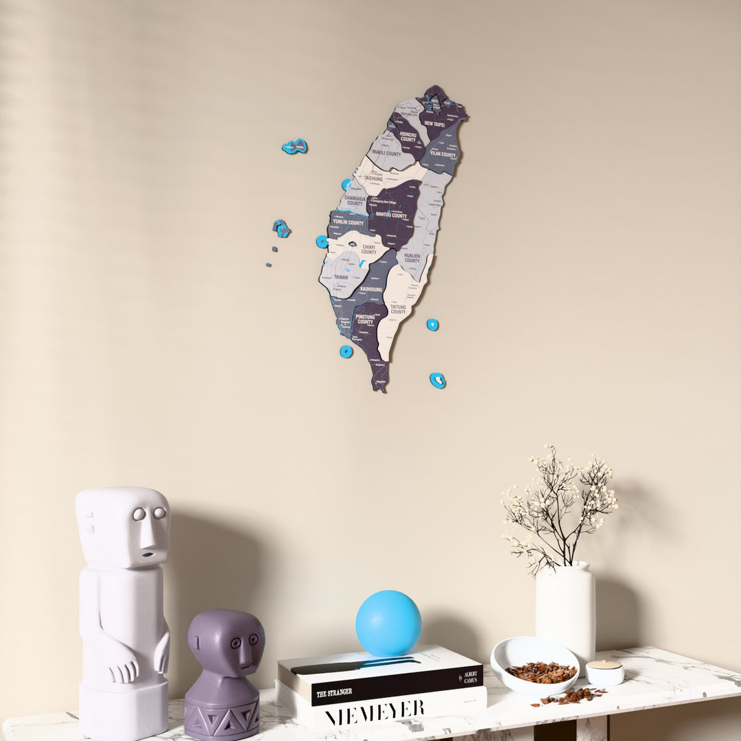 Nimbus Taiwan wooden wall map on a beige wall above a console with figurines