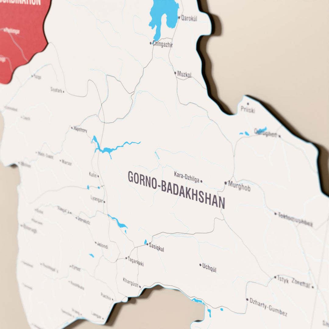 Close-up of the Flag colored Tajikistan wooden wall map with layered regions and printed names