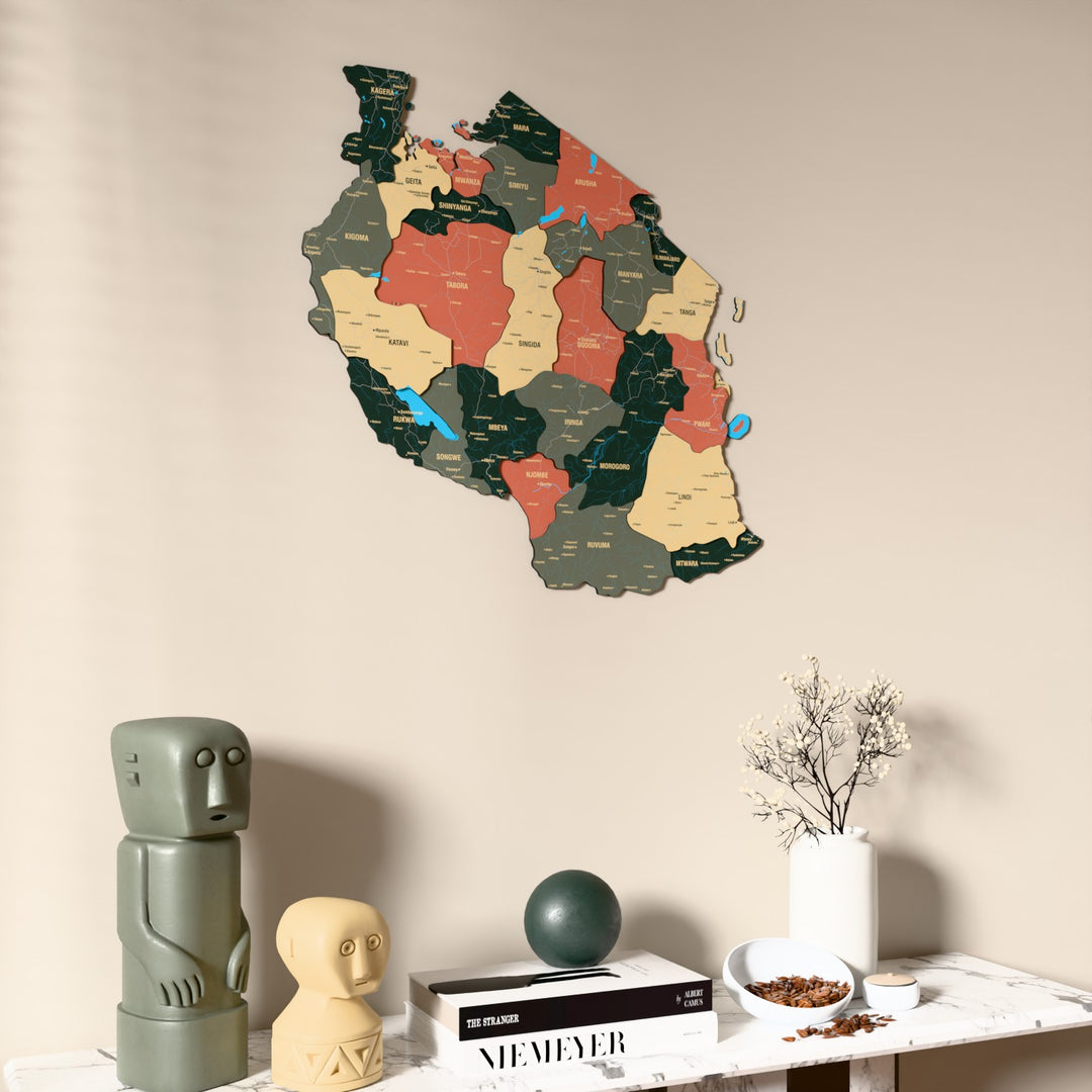 Sage Tanzania wooden wall map on a beige wall above a console with figurines