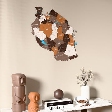 Soil Tanzania wooden wall map on a beige wall above a console with figurines