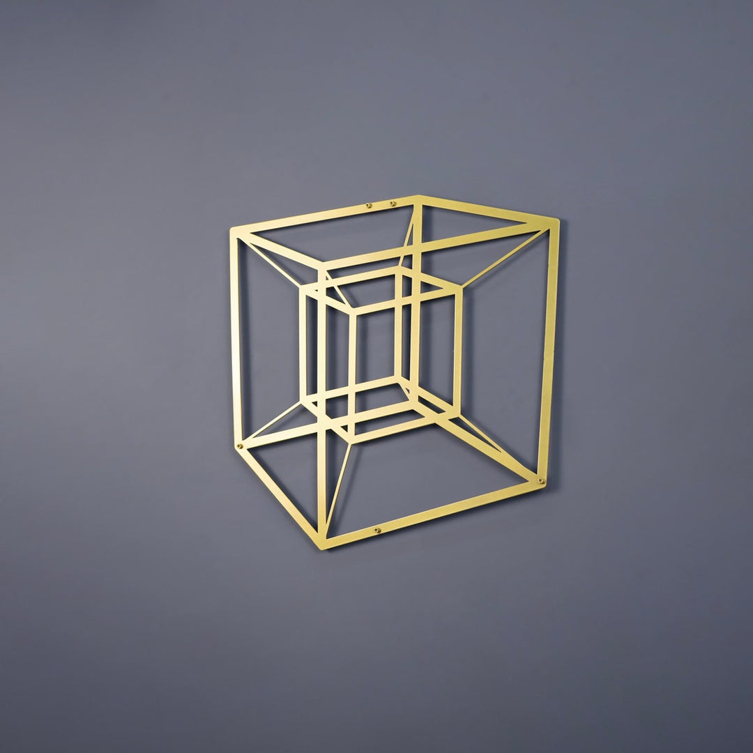 Gold tesseract cube metal wall art on a grey wall