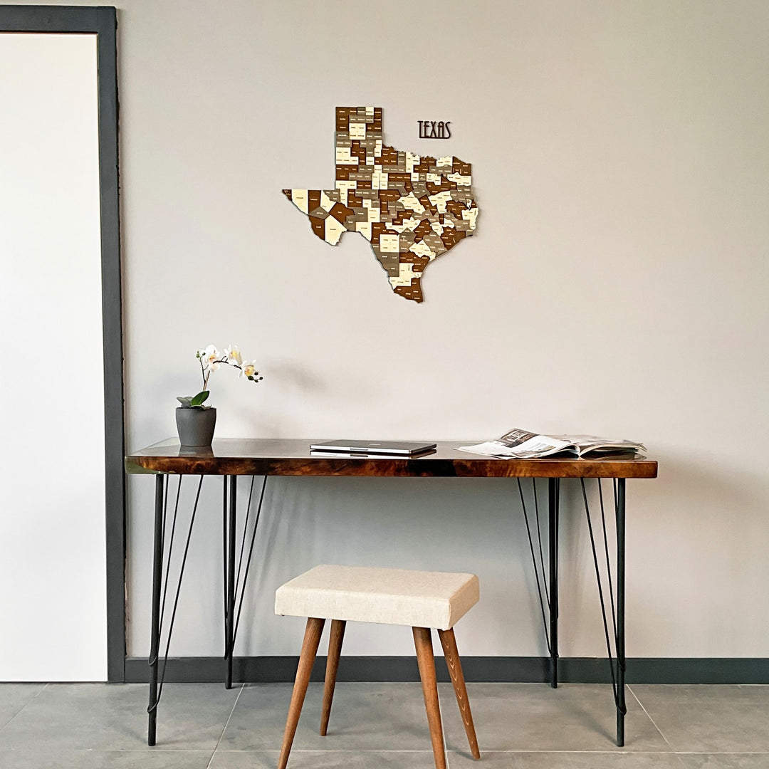 Texas wooden wall map above a dark console table with iron legs and a cream stool, wide view