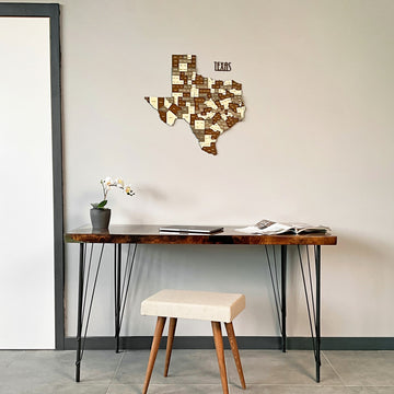 Texas wooden wall map above a dark console table with iron legs and a cream stool, wide view