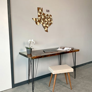 Texas wooden wall map with TEXAS lettering on a light gray wall above a live-edge desk, wide view