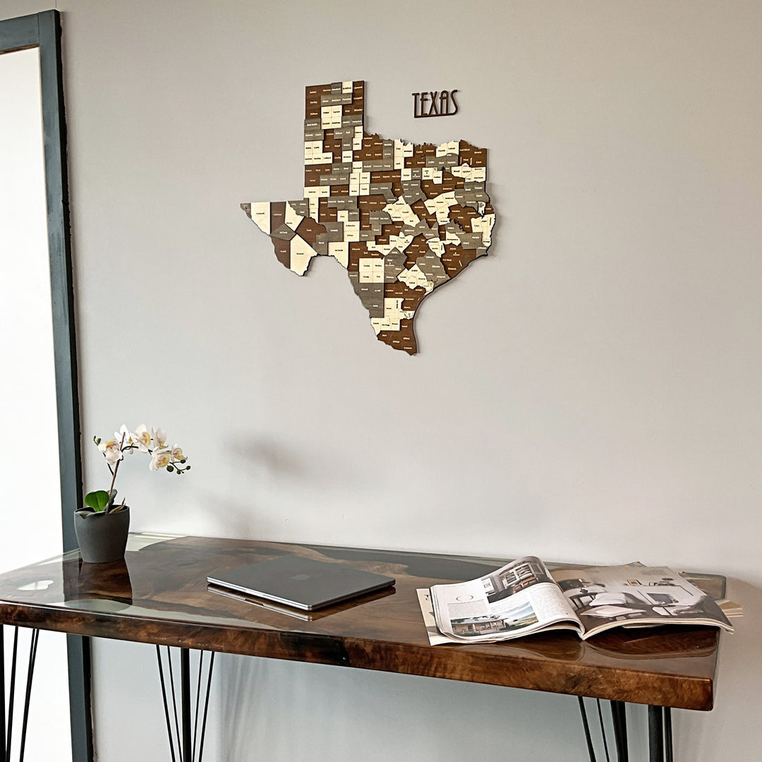 Texas wooden map on a gray wall above a resin edge desk with a laptop, angled shot