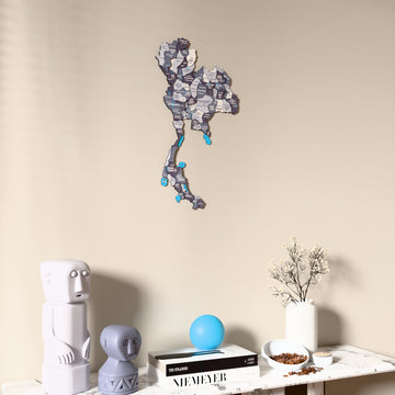 Nimbus Thailand wooden wall map on a beige wall above a console with figurines