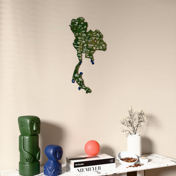 Satellite Thailand wooden wall map on a beige wall above a console with figurines