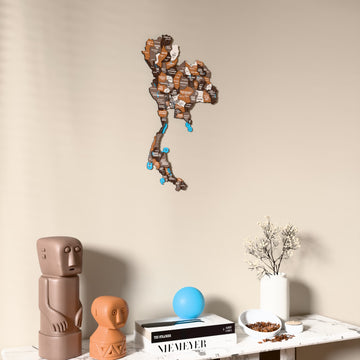 Soil Thailand wooden wall map on a beige wall above a console with figurines