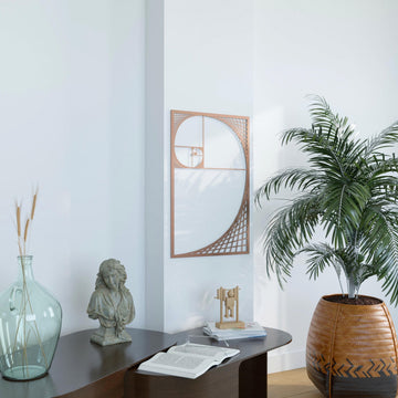 Copper Fibonacci spiral metal wall art in a rectangular frame above a black console table