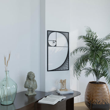 Black Fibonacci spiral metal wall art above a table with a palm in a wicker pot