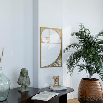 Gold Fibonacci spiral metal wall art in a rectangular frame above a black console table