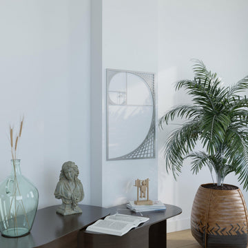 Silver Fibonacci spiral metal wall art above a table with a palm in a wicker pot