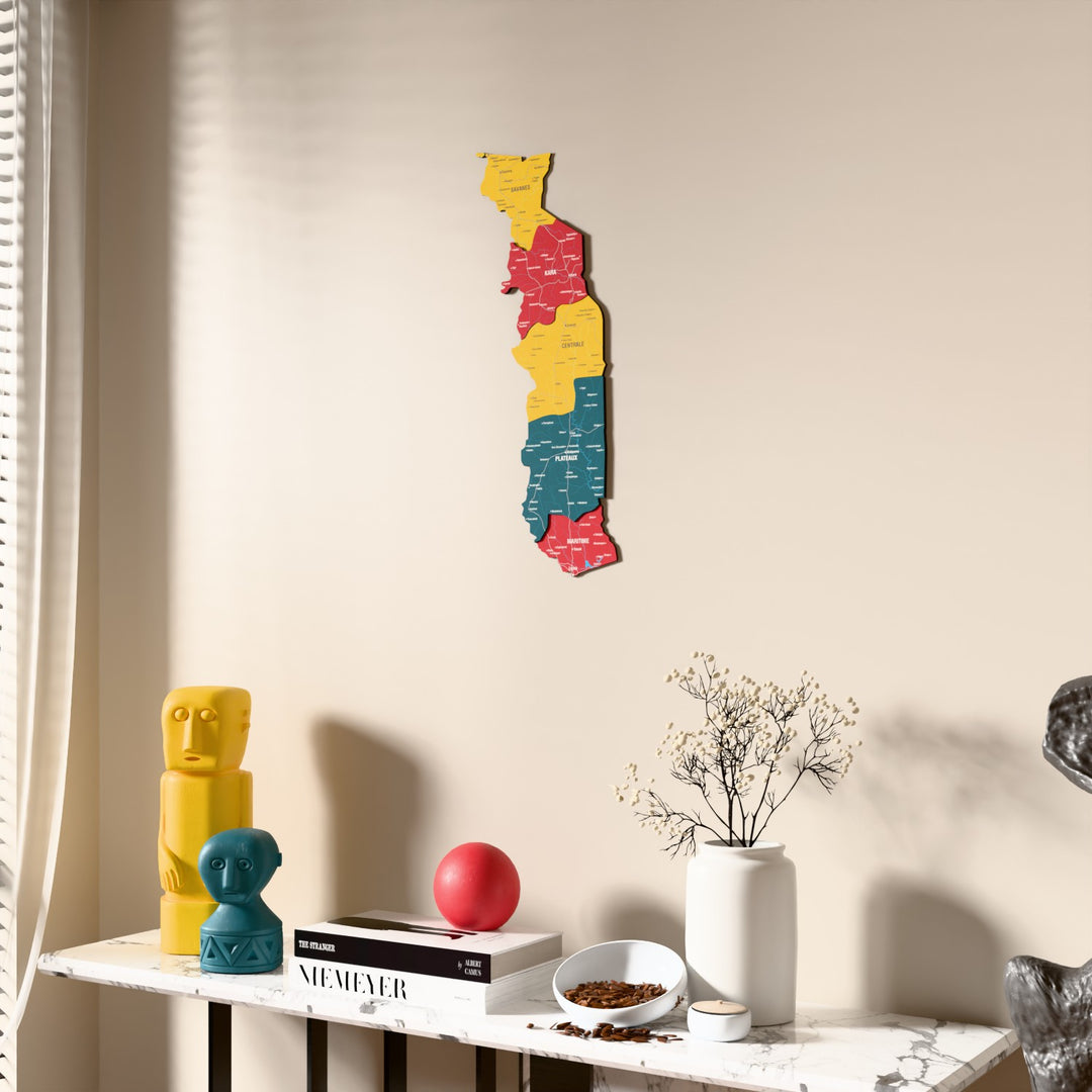 Flag colored Togo wooden wall map beside a sheer curtain, angled view