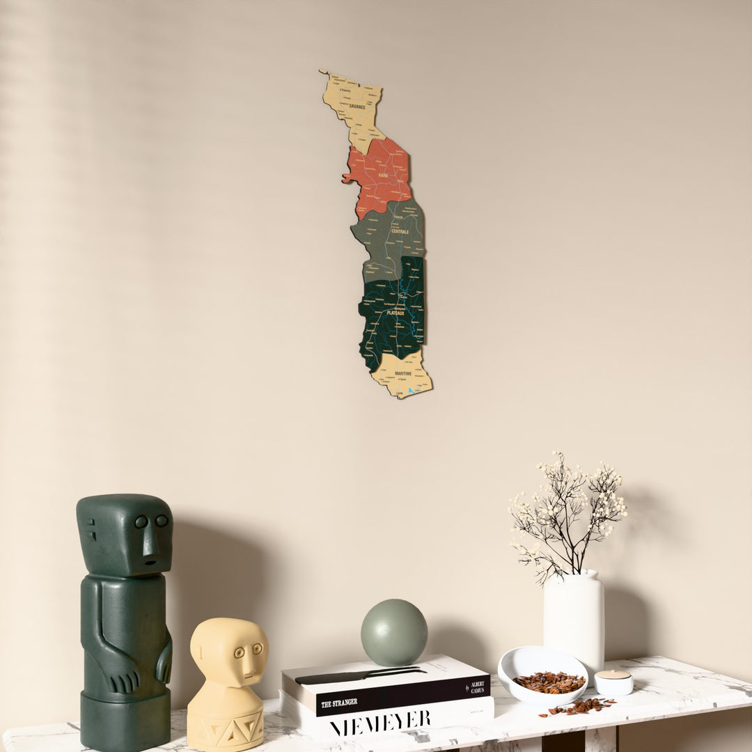 Sage Togo wooden wall map on a beige wall above a console with figurines