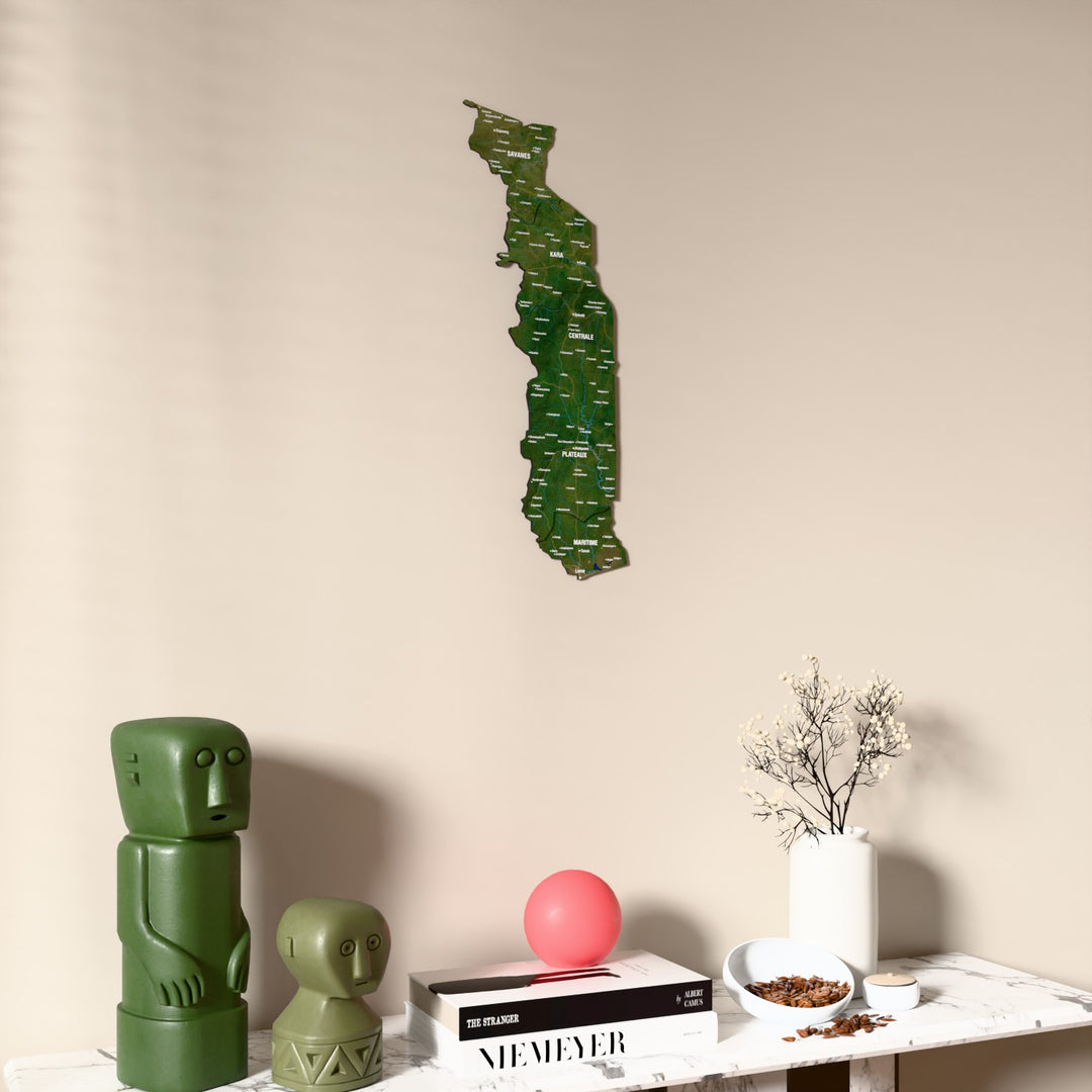 Satellite Togo wooden wall map on a beige wall above a console with figurines