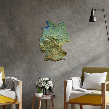 Topographic Germany metal wall map on a concrete-textured wall between two armchairs and a floor lamp