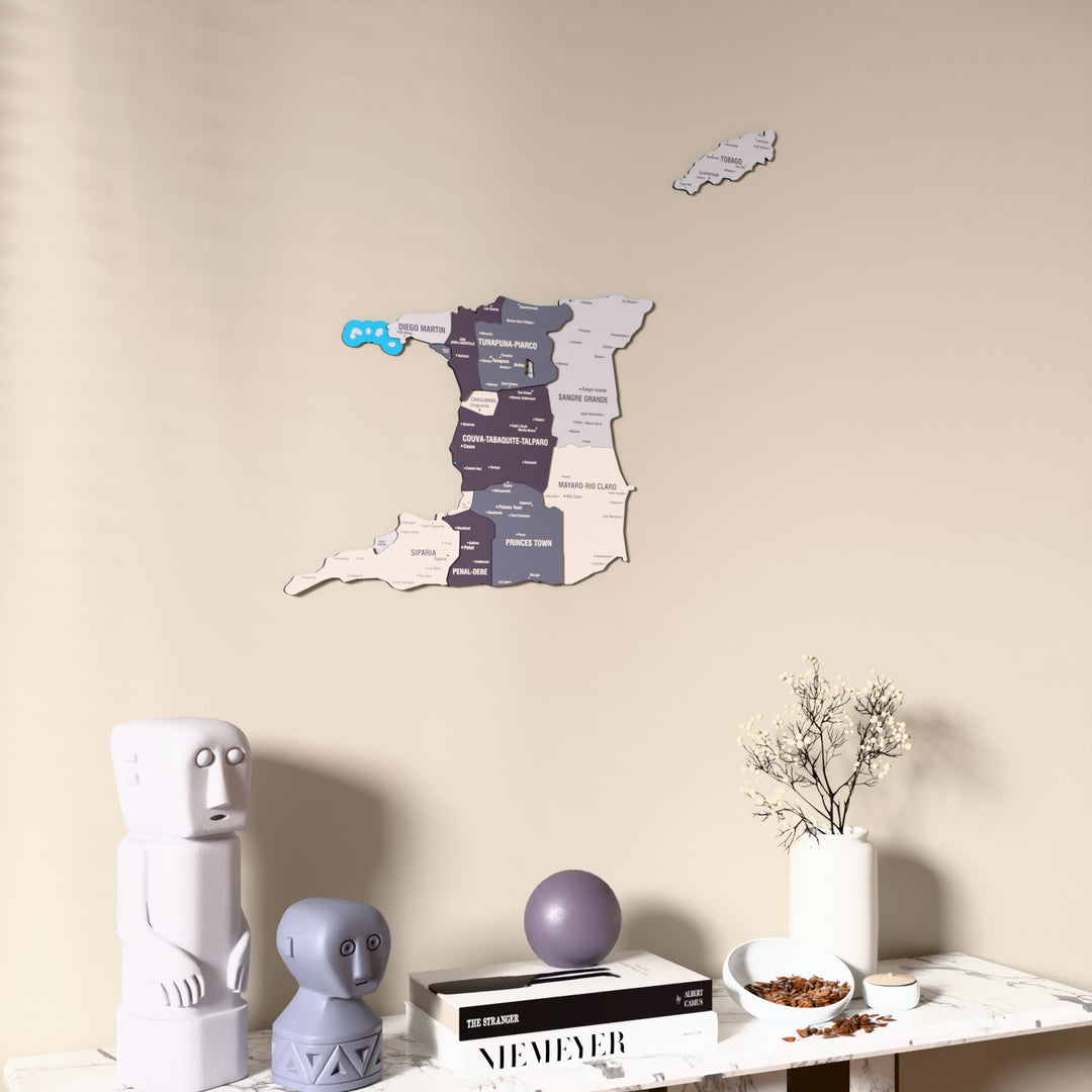 Nimbus Trinidad and Tobago wooden wall map on a beige wall above a console with figurines