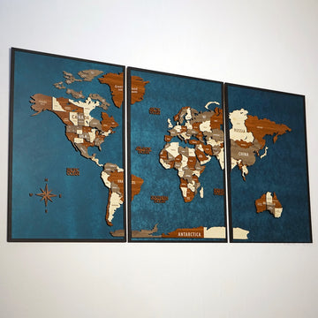 Three-panel wooden world map with a compass rose, angled view from the left on a white wall
