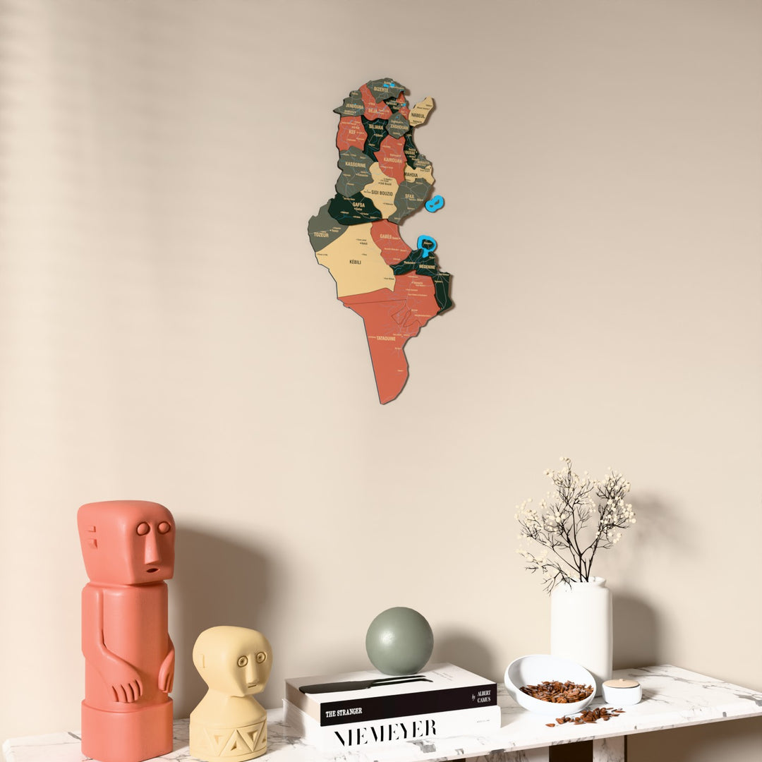 Sage Tunisia wooden wall map on a beige wall above a console with figurines