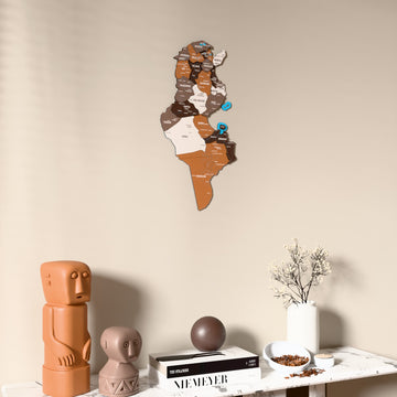 Soil Tunisia wooden wall map on a beige wall above a console with figurines