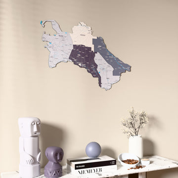 Nimbus Turkmenistan wooden wall map on a beige wall above a console with figurines