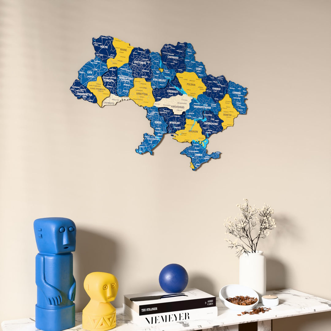 Flag colored Ukraine wooden wall map on a beige wall above a console with figurines