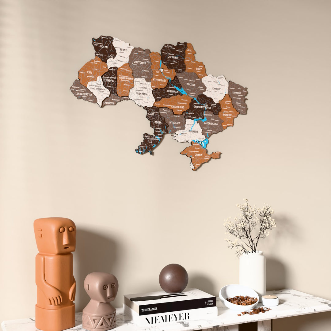 Soil Ukraine wooden wall map on a beige wall above a console with figurines