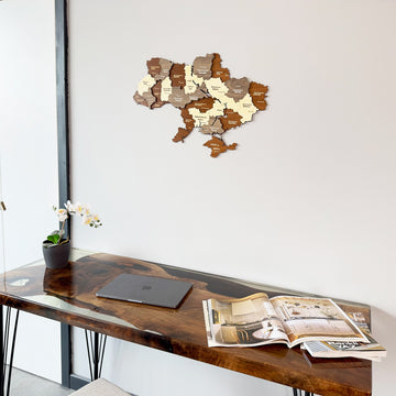 Ukraine wooden wall map above the corner of a resin desk with an open magazine, tight crop