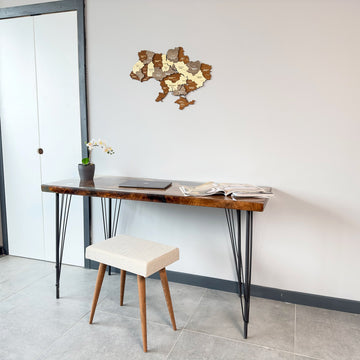 Ukraine wooden wall map above a desk and white stool next to a door, mid-distance view