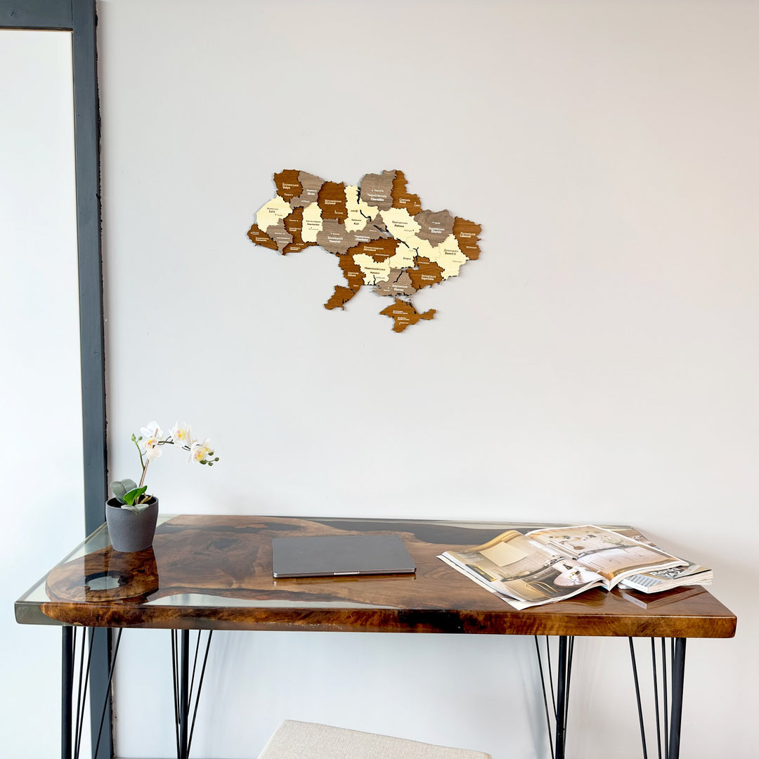 Ukraine wooden wall map above a resin-edged desk with an orchid, close view