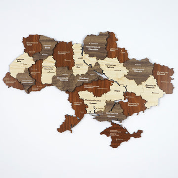 Ukraine wooden wall map with oblast names in brown, gray and cream layered wood, front view on a white wall