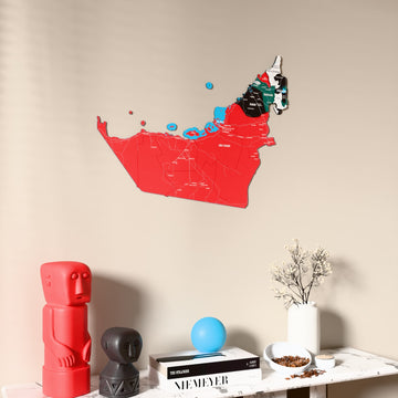 Flag colored United Arab Emirates wooden wall map on a beige wall above a console with figurines