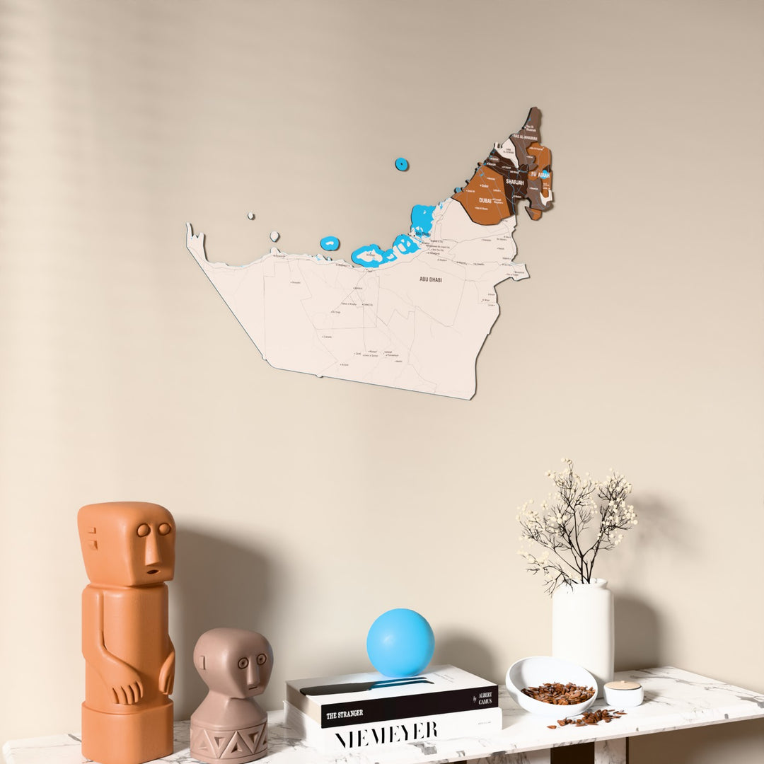 Soil United Arab Emirates wooden wall map on a beige wall above a console with figurines