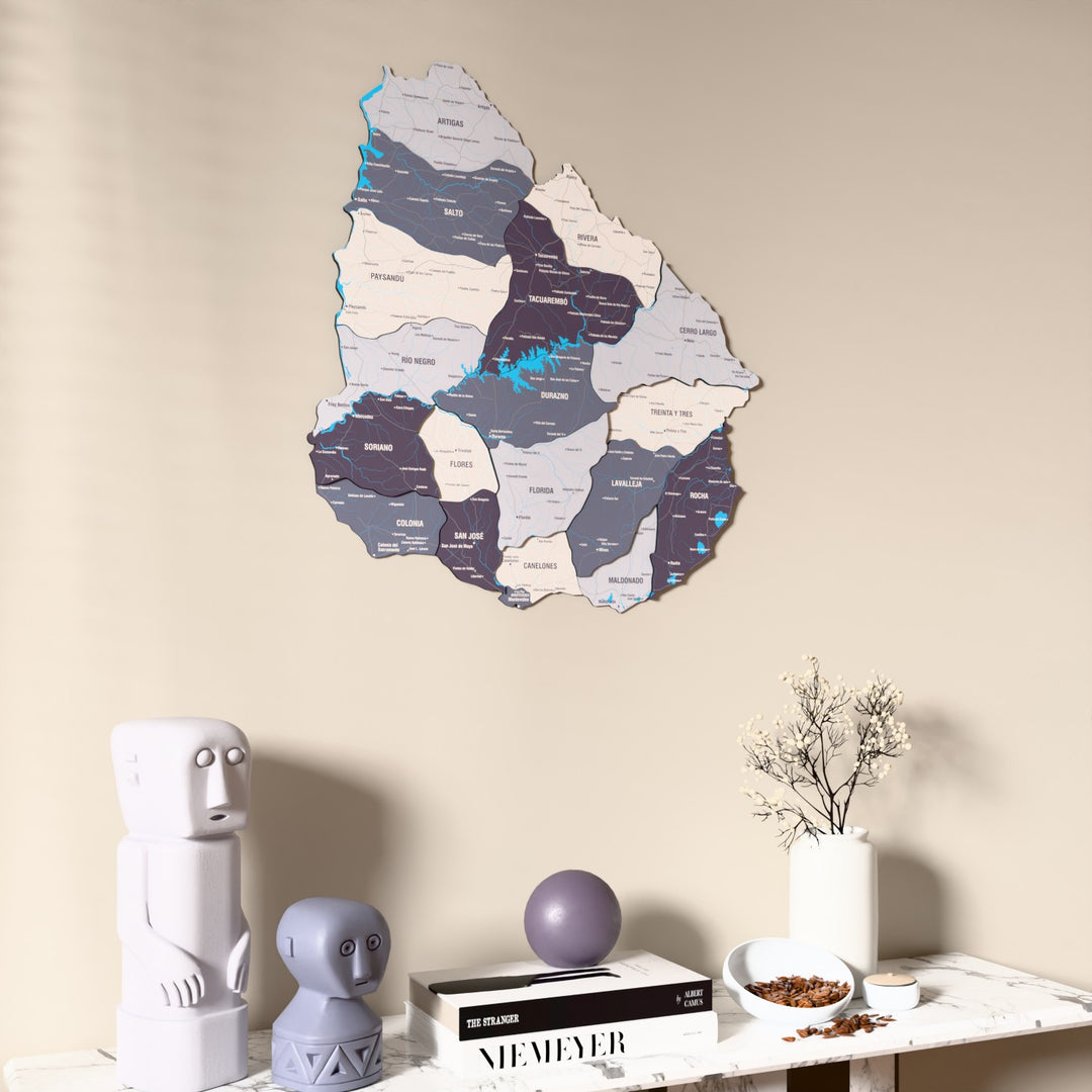 Nimbus Uruguay wooden wall map on a beige wall above a console with figurines