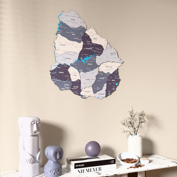 Nimbus Uruguay wooden wall map on a beige wall above a console with figurines