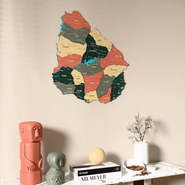 Sage Uruguay wooden wall map on a beige wall above a console with figurines