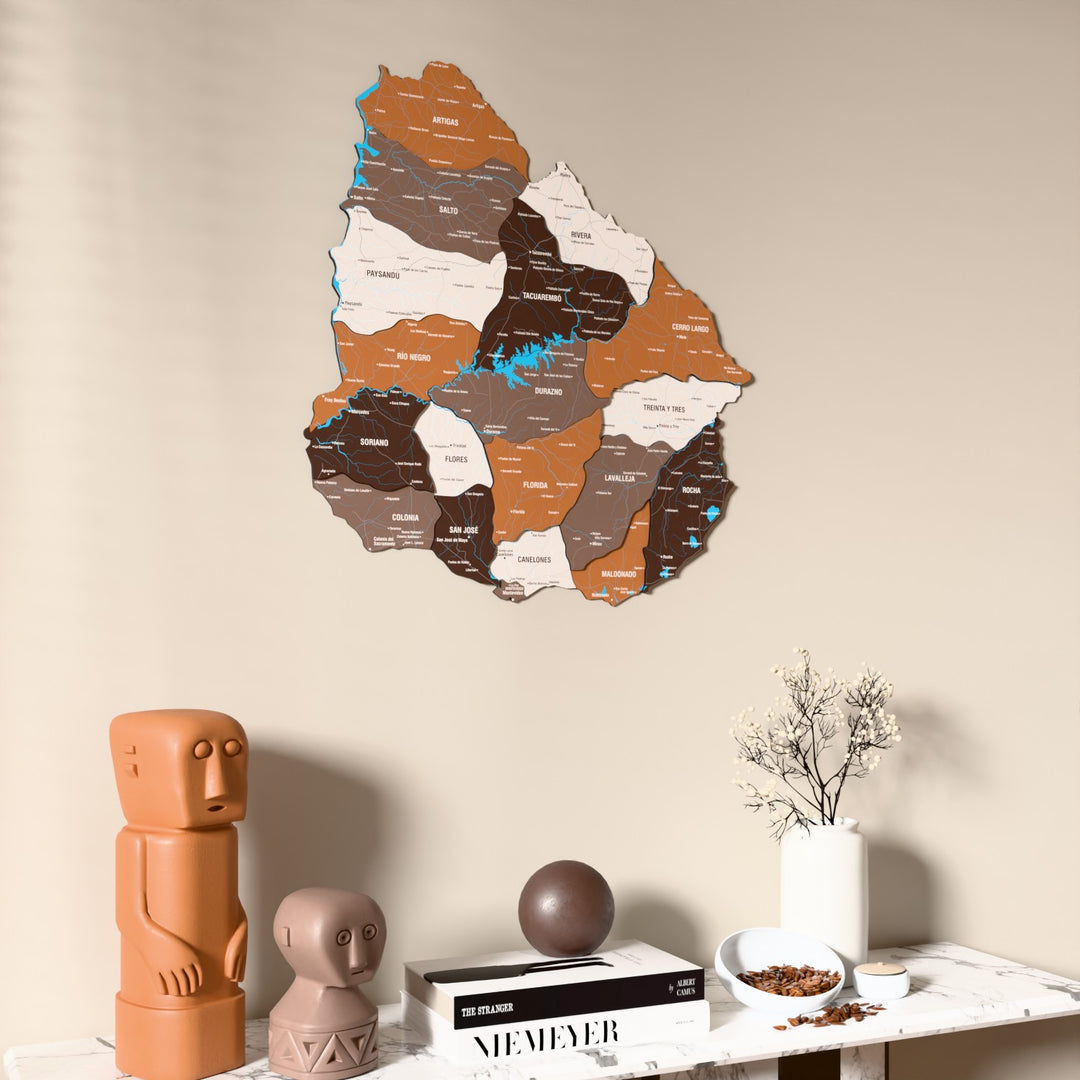 Soil Uruguay wooden wall map on a beige wall above a console with figurines