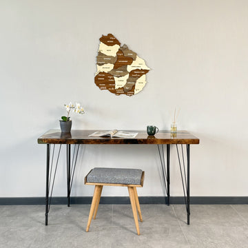 Wooden Uruguay map above a hairpin-leg desk and gray stool, wide view of the wall