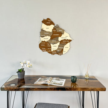 Wooden Uruguay map above a dark desk with an open magazine