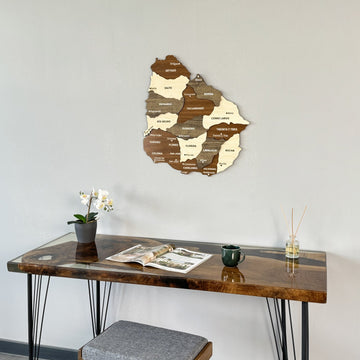 Uruguay wood wall map on a light wall above a desk, closer view from the right